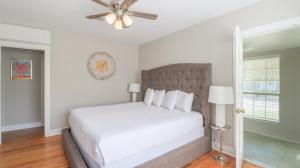 1 dormitorio blanco con 1 cama y ventilador de techo en House on Cherokee, en Biloxi