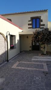 Masullas的住宿－Casa di Nonna Rosa，白色的建筑,设有庭院和窗户