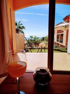 a glass of wine sitting on a table in front of a window at Silvia del Mar in Mijas