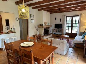 a living room with a wooden table and a couch at LA HULOTTE, VILLA ENTRE MER ET FORET -- draps et serviettes non fournis -- in Saint-Trojan-les-Bains +11 photos