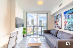 sala de estar con sofá y ventana grande en Downtown Miami Condos by Lua Host en Miami