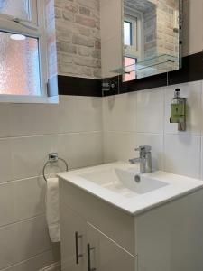 een witte badkamer met een wastafel en een spiegel bij The Headlands Hotel in Scarborough