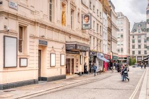 una calle de la ciudad con gente caminando por la calle en Loft Piccadilly Circus Apartment, en Londres