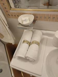 a shelf with three rolled towels and a sink at Studio Apollonia in Alexandroupoli