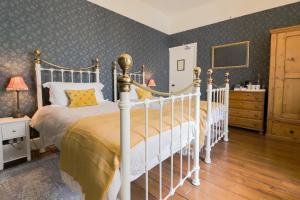 1 dormitorio con cama blanca y almohadas amarillas en Aaron House en Port Saint Mary