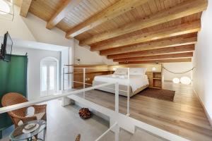 a bedroom with a white bed and wooden ceilings at HyblaLifeRooms in Ragusa