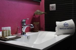 a sink in a bathroom with a pink wall at Monte de Portugal in Montargil