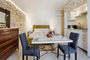 a bedroom with a bed and a table and chairs at HyblaLifeRooms in Ragusa
