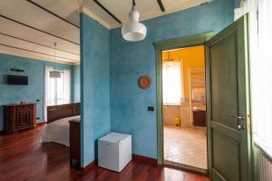 een slaapkamer met blauwe muren en een bed en een deur bij Alba Morus in La Morra