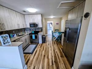 cocina con suelo de madera y nevera de acero inoxidable en Modern & Comfy Lagoon Oasis - River Views - Parking en Titusville