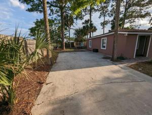 a driveway leading to a house with palm trees at Modern & Comfy Lagoon Oasis - River Views - Parking in Titusville