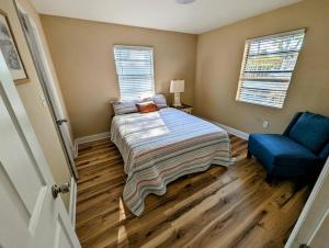 a bedroom with a bed and a blue chair at Modern & Comfy Lagoon Oasis - River Views - Parking in Titusville