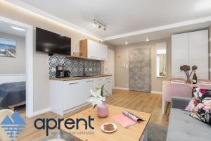 a kitchen and a living room with a table in a room at Apartament AURI Pobierowo Baltic Apartments - Aprent in Pobierowo