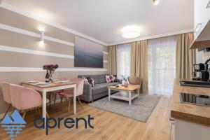 a living room with a couch and a table at Apartament AURI Pobierowo Baltic Apartments - Aprent in Pobierowo