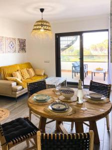 sala de estar con mesa de madera y sillas en Sunny Luxury Apartment with two-level terrace, two swimming pools, next to golf course, en Caleta de Fuste