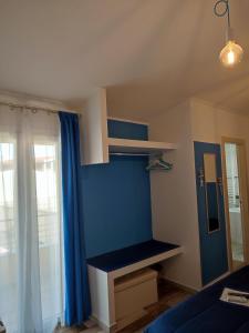 una habitación con una pared azul con un banco. en B&B Fradama' Holiday, en Dorgali