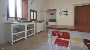 a kitchen with a counter and two red chairs at Italianway - Piazza Campidoglio 3 in Lenno