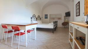 a room with a bed and a table and chairs at Italianway - Piazza Campidoglio 3 in Lenno