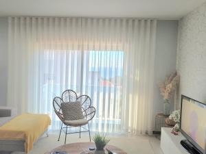 un soggiorno con una sedia di fronte a una finestra di Panoramic Villa Mar a Nazaré