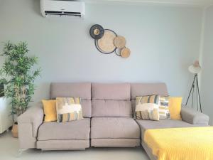 a couch in a living room with yellow pillows at Panoramic Villa Mar in Nazaré