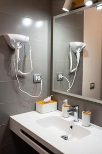 a bathroom with a sink and a mirror and a blow dryer at Sunny Luxury Apartment with two-level terrace, two swimming pools, next to golf course in Caleta De Fuste