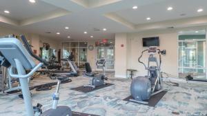 un gimnasio con cintas de correr y máquinas en una habitación en Legacy II 1107, en Gulfport