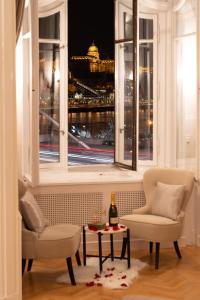 Habitación con 2 sillas y ventana con vistas. en Matilda Luxury Suite Apartment en Budapest