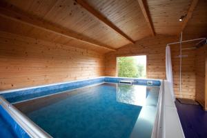 uma grande piscina numa casa de madeira em The Byre, Back Borland Holday Cottages em Stirling