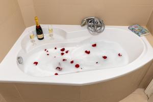 bañera blanca con corazones en el suelo en Matilda Luxury Suite Apartment en Budapest
