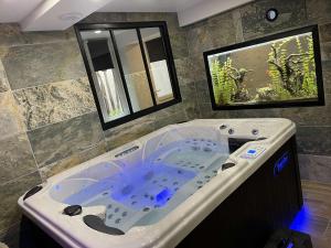 a large bath tub in a bathroom with a fishtank at Nuit de la sagesse "jacuzzi terrasse et parking privé" in Rouen +18 photos