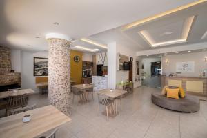 uma sala de estar com mesas e cadeiras e um sofá em Minos Boutique Hotel em Agía Galíni