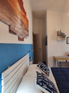 1 dormitorio con 1 cama con pared azul en B&B Fradama' Holiday, en Dorgali