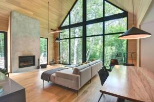 a living room with a couch and a fireplace at 1 Impasse du Cardinal - Lac Superior Chalet w Spa Sauna & Games Room in Mont-Tremblant