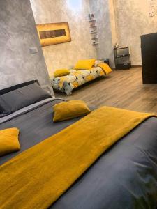 two beds with yellow pillows in a room at La Clessidra B&B in Bari