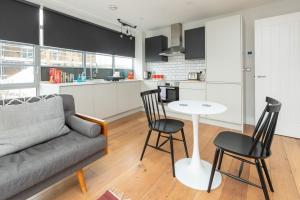 a living room with a couch and a table and chairs at Central and Bright 1 Bedroom Flat - Peckham in London