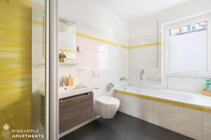 biała łazienka z umywalką, toaletą i oknem w obiekcie Pineapple Apartments Dresden Zwinger II - 70 qm - 1x free parking w Dreźnie