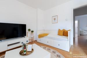 sala de estar blanca con cama y TV de pantalla plana en Pineapple Apartments Dresden Zwinger II - 70 qm - 1x free parking, en Dresden