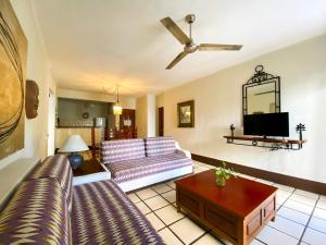 ein Wohnzimmer mit einem Sofa und einem TV in der Unterkunft Puerto de Luna Pet Friendly and Family Suites in Puerto Vallarta