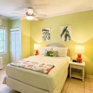 a bedroom with a bed with two lamps and a ceiling fan at Westwinds Inn in Key West
