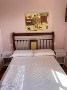 a bed in a room with two tables and a picture on the wall at Apartamentos Hoz del Huécar in Cuenca