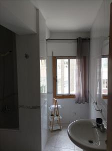 a bathroom with a tub and a sink and a window at Dona Branca in Quiroga