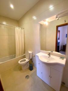bagno con lavandino, servizi igienici e specchio di Mindelo Beach House a Vila Chã