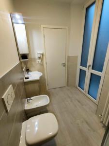 a bathroom with a toilet and a sink and a mirror at CARrooms in Carrù