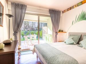 een slaapkamer met een bed en een glazen schuifdeur bij Apartment Le Parc de La Ronceray-5 by Interhome in Dinard