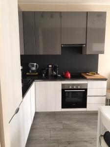 a kitchen with white cabinets and black appliances at [Portello] La casa di Andrea in Milan