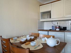 kuchnia z drewnianym stołem i zestawem do parzenia herbaty w obiekcie Apartment Bleu Marine-10 by Interhome w mieście Lacanau-Océan