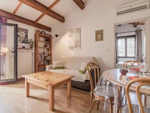 een woonkamer met een tafel en een bank bij Apartment L'Aquilon by Interhome in Noves