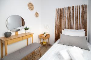 Dormitorio con cama con espejo y banco en Olive Forest Villa, en Koxaré