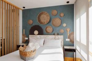 1 dormitorio con 1 cama y una pared con cestas en La Plazuela Urban Estudio, en Gijón