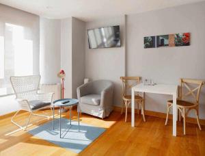 ein Wohnzimmer mit einem Tisch und Stühlen in der Unterkunft La Plazuela Urban Estudio in Gijón